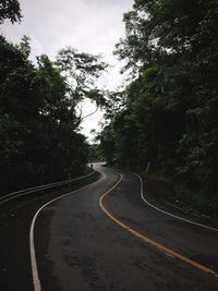 Road amidst trees against sky