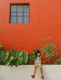 Full length of girl standing by building