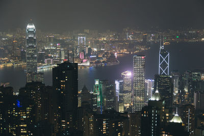 High angle view of city by river at night