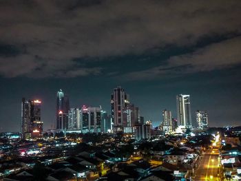 Illuminated cityscape against sky at night