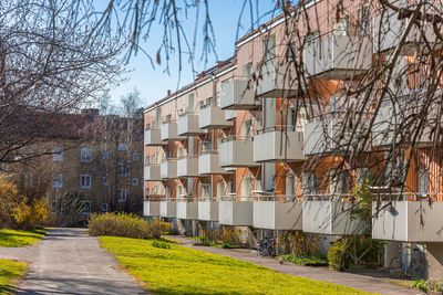 Facade of an orange apartment building with white balconies
