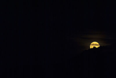 Low angle view of silhouette building against sky at night