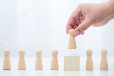 Close-up of hand holding toy against white background