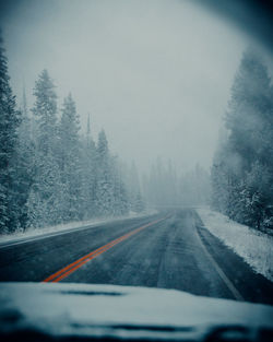 Road seen through car windshield during winter