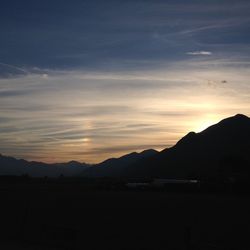 Silhouette landscape against sky at sunset