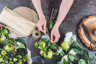 Florist woman make green organic flower fruit edible bouquet