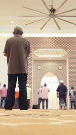 Rear view of people standing in temple