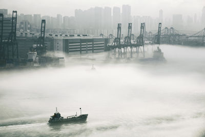 Boat sailing in river during foggy weather