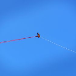 Low angle view of vapor trail against clear blue sky