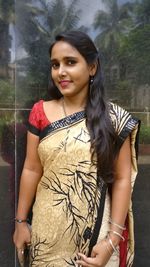 Portrait of smiling young woman standing outdoors