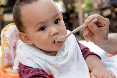 Cropped hand of grandmother feeding grandson