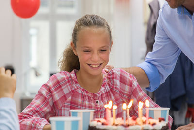 Parents with girl looking at birthday cake
