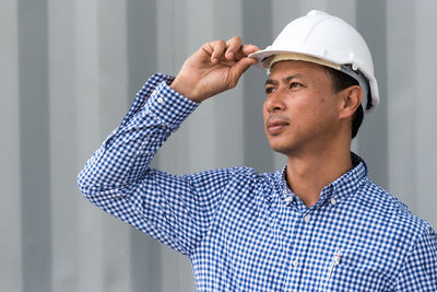 Architect wearing hardhat at construction site