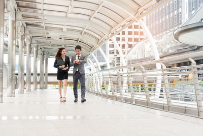 Business people walking on footbridge in city