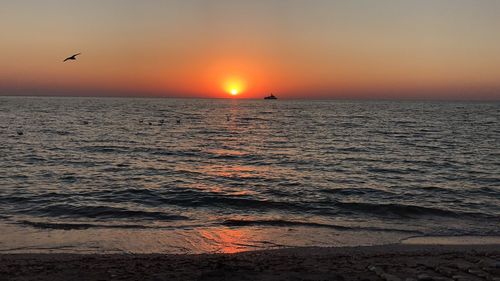 Scenic view of sea against orange sky