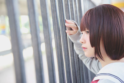 Woman standing on by fence