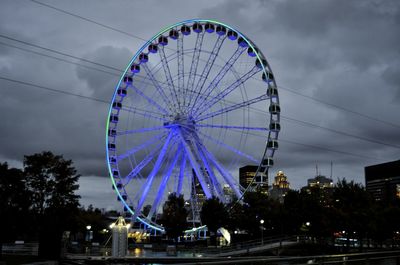 Ferris wheel against sky in city at dusk