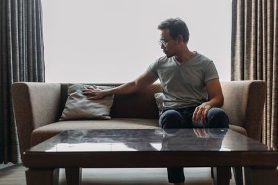 Young man sitting on sofa at home