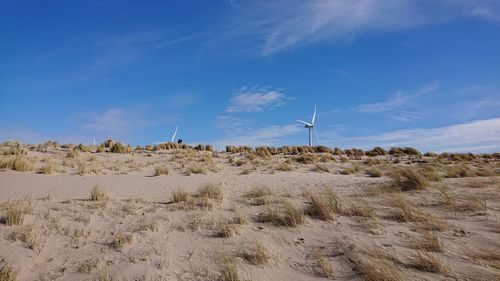 Wind turbines on land against sky