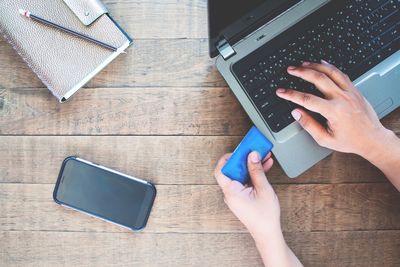 High angle view of man using mobile phone on table