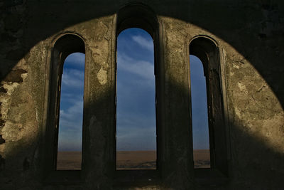 View of sky seen from old arch window