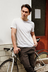 Portrait of young man standing on bicycle