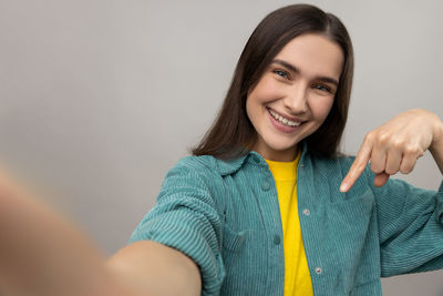 Portrait of young woman against wall