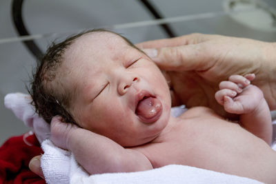 Cropped hands of doctor holding baby boy at hospital