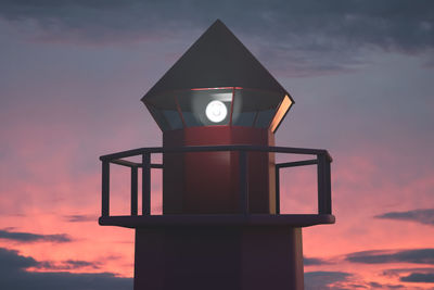 Low angle view of illuminated tower against sky during sunset