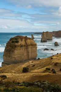 Rock formations by sea against sky