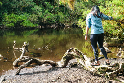 Full length of man standing on rock by lake