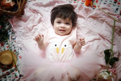 High angle portrait of cute baby girl on bed