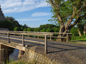 Bridge by trees against sky