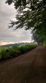 Country road against cloudy sky