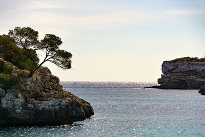 Rock formation in sea against sky