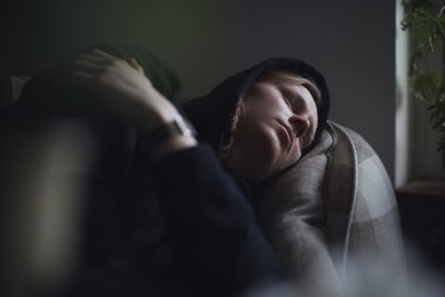 Sad man facing depression lying in bed