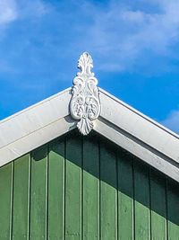 Low angle view of metal gate against sky