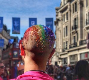 Rear view of man with multi colored buildings in city