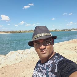 Close-up of man standing at beach during sunny day