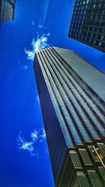 Low angle view of modern building against blue sky