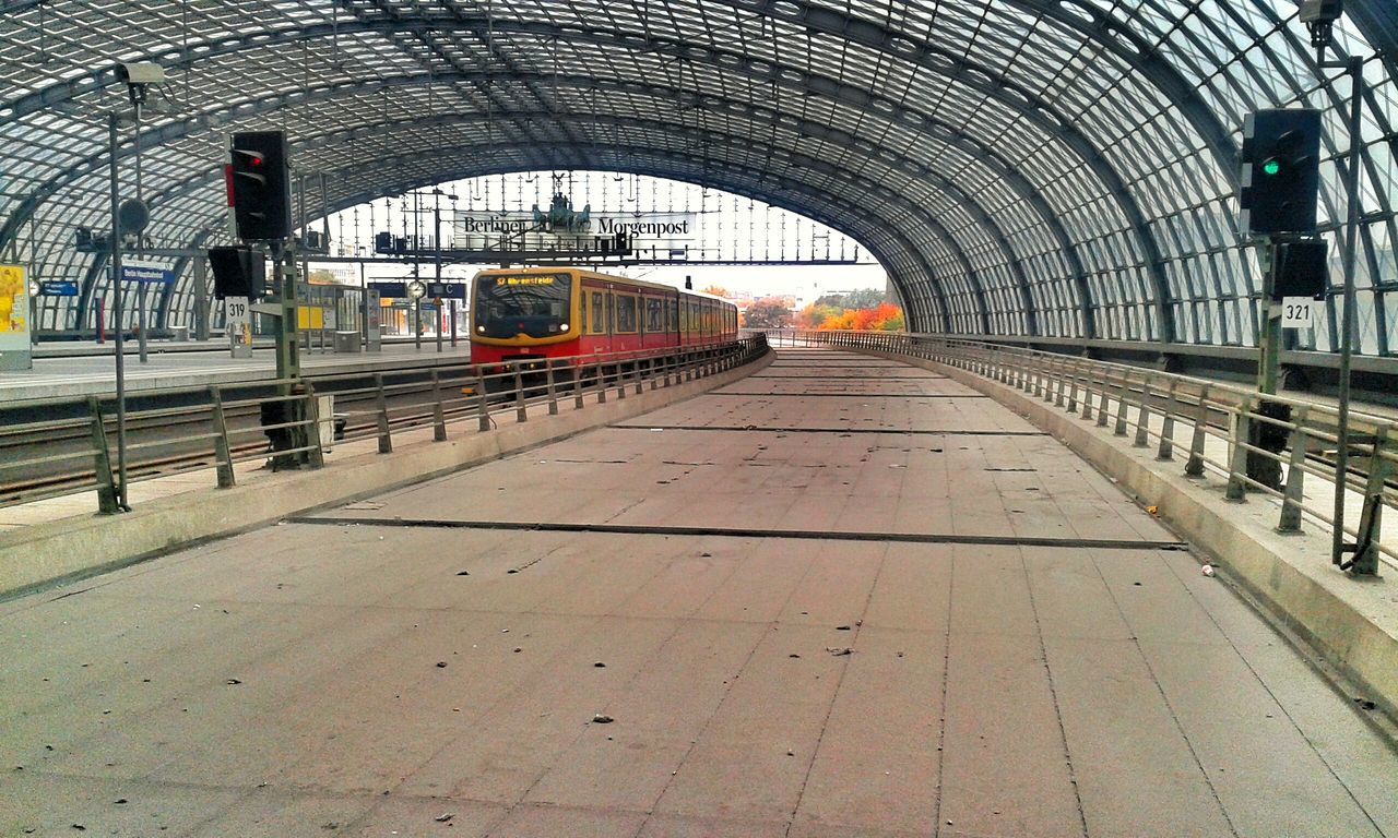 transportation, railroad track, the way forward, built structure, rail transportation, architecture, railroad station platform, public transportation, railroad station, diminishing perspective, vanishing point, incidental people, mode of transport, arch, travel, connection, train - vehicle, walking, day