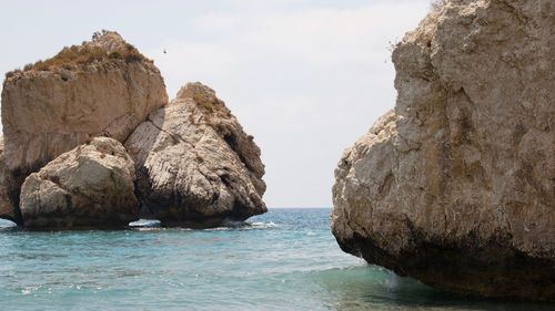 Rocks in sea against sky