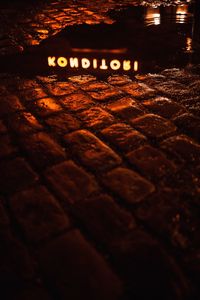 High angle view of illuminated text on wood at night