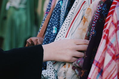 Midsection of woman holding a blouse at a vintage shop