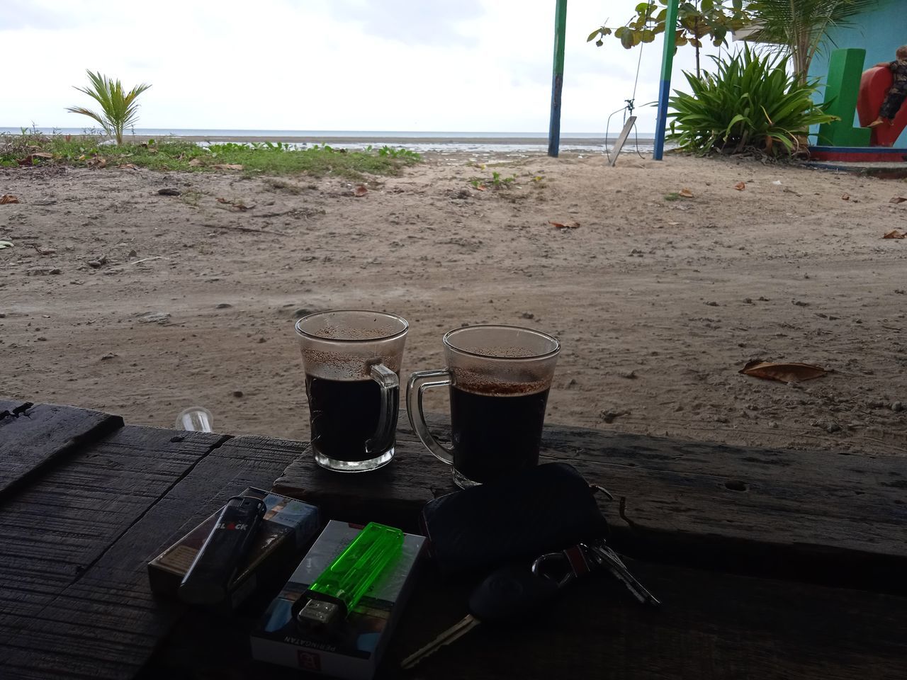 drink, land, beach, food and drink, nature, sky, sand, palm tree, tropical climate, refreshment, table, day, water, plant, no people, tree, outdoors, drinking glass, glass, soft drink, sea, household equipment, wood, cloud