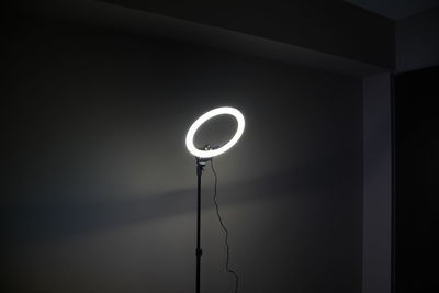 Low angle view of illuminated electric lamp in darkroom