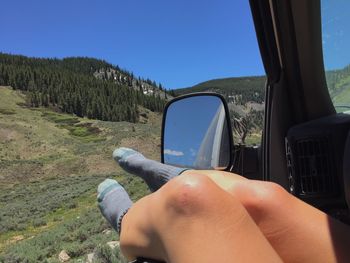 Midsection of man driving car against sky