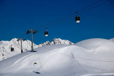 Low angle view of overhead cable car against blue sky