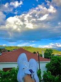 Rear view of woman with umbrella against sky