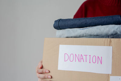 Midsection of woman holding text against white background